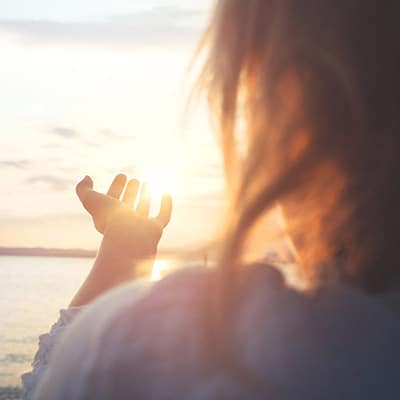 Une femme zen devant un coucher de soleil